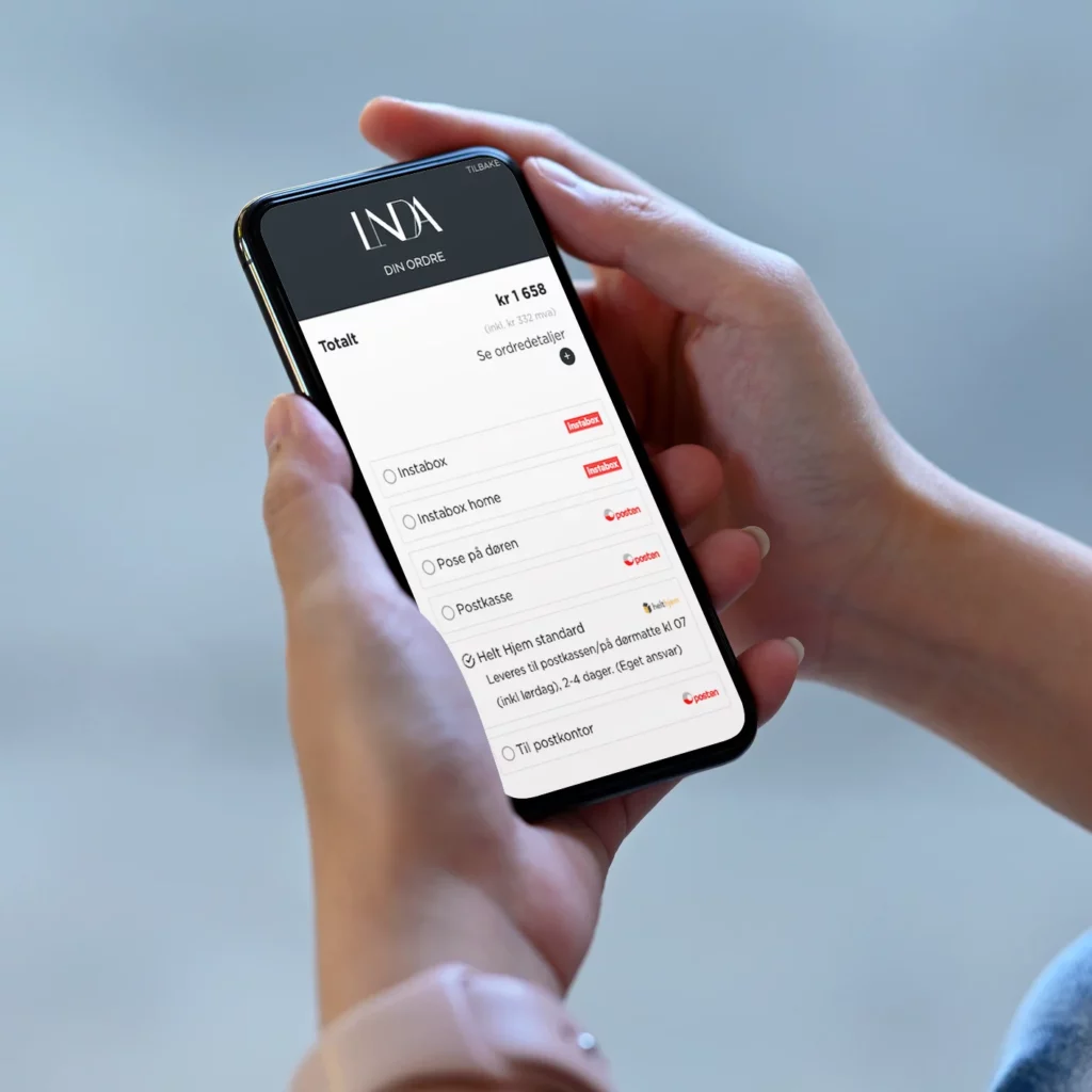 bilde av mobil som viser fraktmetoder i nettbutikken lindajohansen.no
